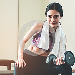 Slim asian woman is working out with dumbbell