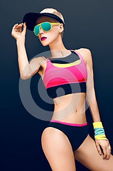 Slim athletic fitness blonde on a black background in the fashion sportswear