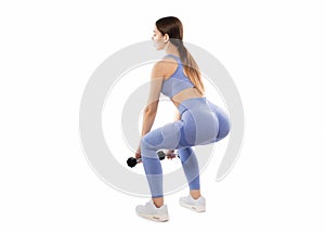 Slim, bodybuilder girl, lifts heavy dumbbell training in the gym.