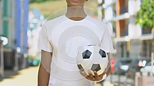 Slim boy holding soccer ball, advertise of youth sports clubs, healthy lifestyle