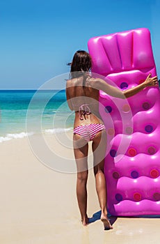 Slim brunette woman sunbathe with an air mattress