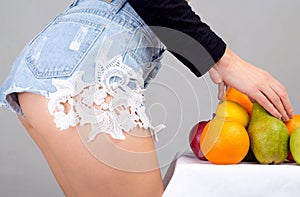 Slim buttocks of young woman. Fruits diet.