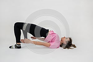 Slim caucasian woman during workout training muscles using rubber bands isolated on white