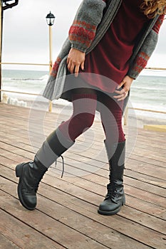 Slim female legs dressed in knee high boots with shoelaces and knitted stockings photo