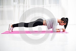 Slim fit girl doing planking core muscles exercise