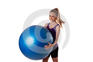 Slim and fit teen girl holding a swiss blue ball. Shot on white background