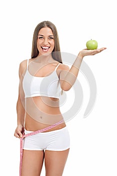 Slim and fit woman with measuring tape and apple