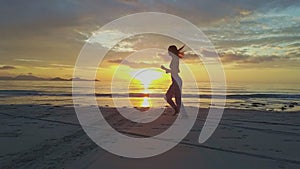 Slim Girl Jogs Barefoot on Wet Beach against Ocean Sunrise