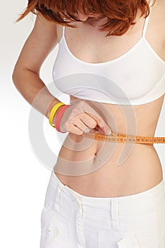 Slim girl measuring waist