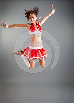 Slim Girl in Open Red Dance Costume Flies in Jump