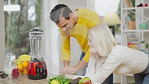 Slim gorgeous Caucasian wife waiting for handsome positive Middle Eastern husband cutting vegetables for healthful