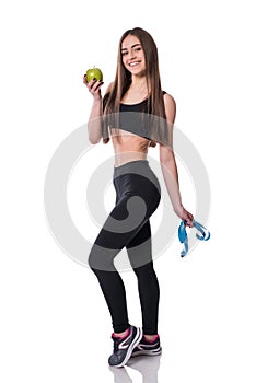 Slim and healthy young woman holding measure tape and apple isolated on white background. Weight loss and diet concept.