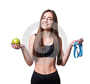 Slim and healthy young woman holding measure tape and apple isolated on white background. Weight loss and diet concept.