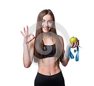 Slim and healthy young woman holding measure tape and apple isolated on white background. Weight loss and diet concept.