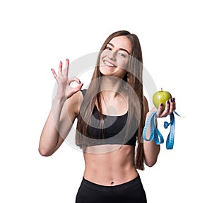 Slim and healthy young woman holding measure tape and apple isolated on white background. Weight loss and diet concept.