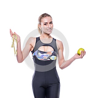 Slim and healthy young woman wearing sportswear tracksuit holding measure tape and green apple isolated on white background.