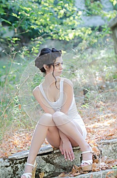 slim lady wear tight short white dress, sitting on sidewalk