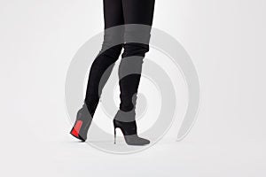 Slim legs in black boots and pants. Walking in high heels. Stiletto shoes