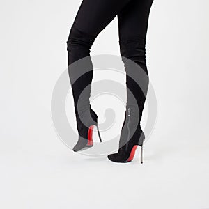 Slim legs in black boots and pants. Walking in high heels. Stiletto shoes
