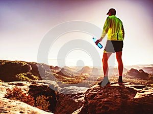 Slim man in yellow jersey, black shorts and running shoes run photo