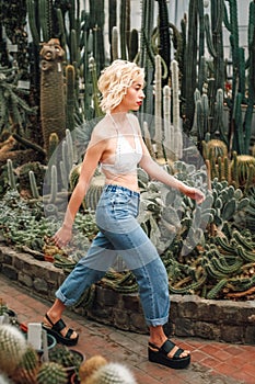 Slim perky female model walking confidently among succulents