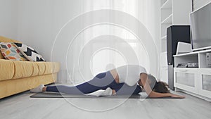 Slim sporty african american woman practicing yoga on a mat. Young woman doing yoga workout in room