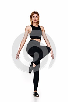 slim woman in black sport leggings and running shoes.