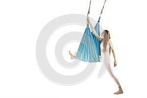 Slim woman engaged in class of aero yoga in hammocks antigravity isolated on white background. Aerial gymnastics