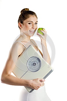 Slim woman holding scales and apple