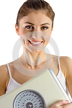 Slim woman holding weighing scales