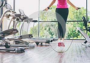Slim woman jumping with skipping rope