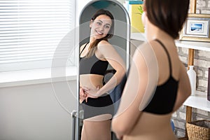 Slim Woman Looking In Mirror photo
