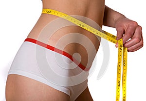 Slim woman measuring tape on belly