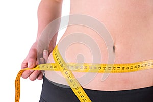 Slim woman measuring waist with tape measure