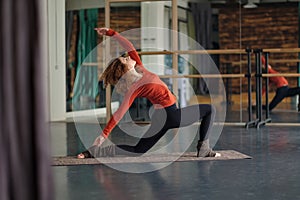 Slim woman practice in yoga studio doing Anjaneyasana