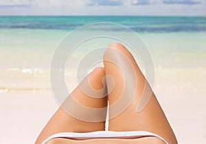 Slim woman's legs on the beach