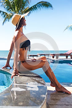 Slim woman in s straw hat and sunglasses sunbath