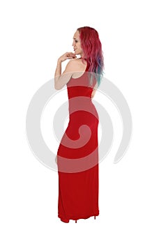 Slim woman standing in profile in a red long dress