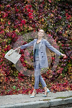 Slim woman walks along street