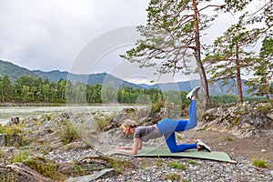 Slim young healthy sports girl doing the donkey kick exercise on all fours arching back straightening leg up concept sport,