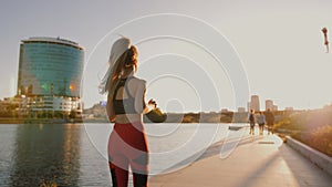Slim young sexy blonde woman jogging on promenade, training outdoors, lifestyle