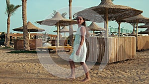 Slim young woman enjoying summer seashore. Long hair girl walking at beach.