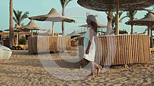 Slim young woman enjoying summer seashore. Long hair girl walking at beach.
