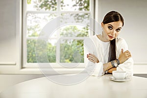 Slim young woman in home interior. Relaxing coffee time. Space for advertising product and your decoration.