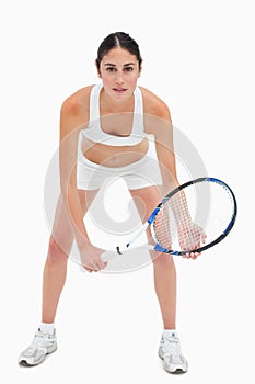 Slim young woman playing tennis in white clothes