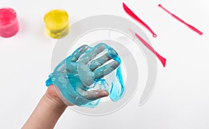 Slime in the hand of a child on a light background. The child plays with mucus and develops fine motor skills of the hands