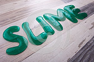 Slime text made from transparent slime diagonally on a wooden surface photo