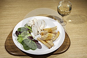 Slimmer`s chicken meal with salad, fries and wine.