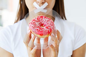 Slimming concept, young woman with sealed mouth giving up junk food