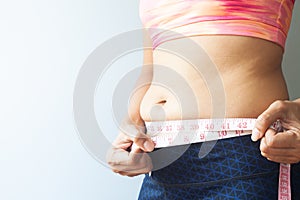 Slimming woman with belly fat, Sporty woman measuring belly fat.